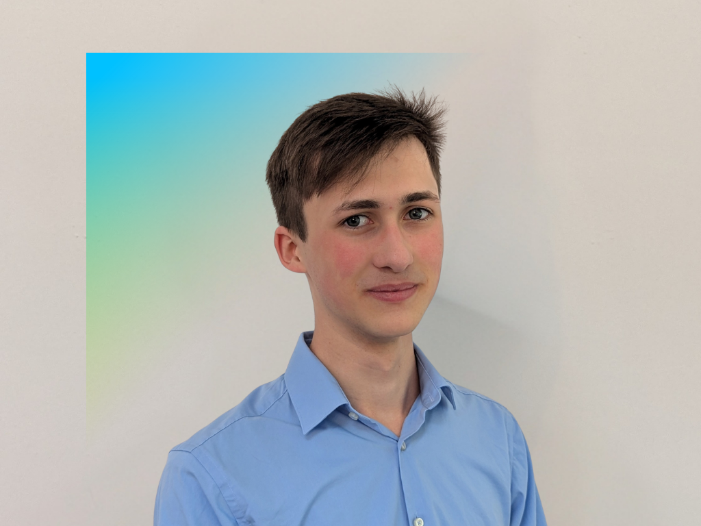 This image is a professional portrait featuring a Bilfinger apprentice wearing a light blue collared shirt against a gradient background of blue and green, emphasizing a formal and polished appearance.