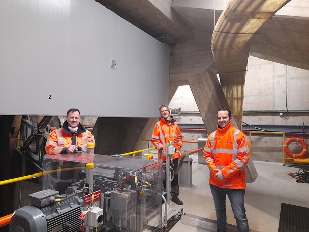 Foto van 3 medewerkers in de technische ruimte van een beweegbare brug