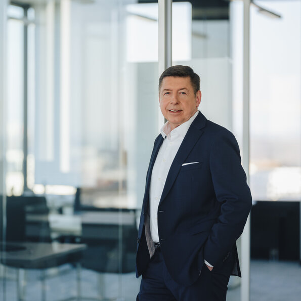 The image features Dr. Thomas Schulz, Bilfinger Group CEO, in a suit within a sleek office environment.