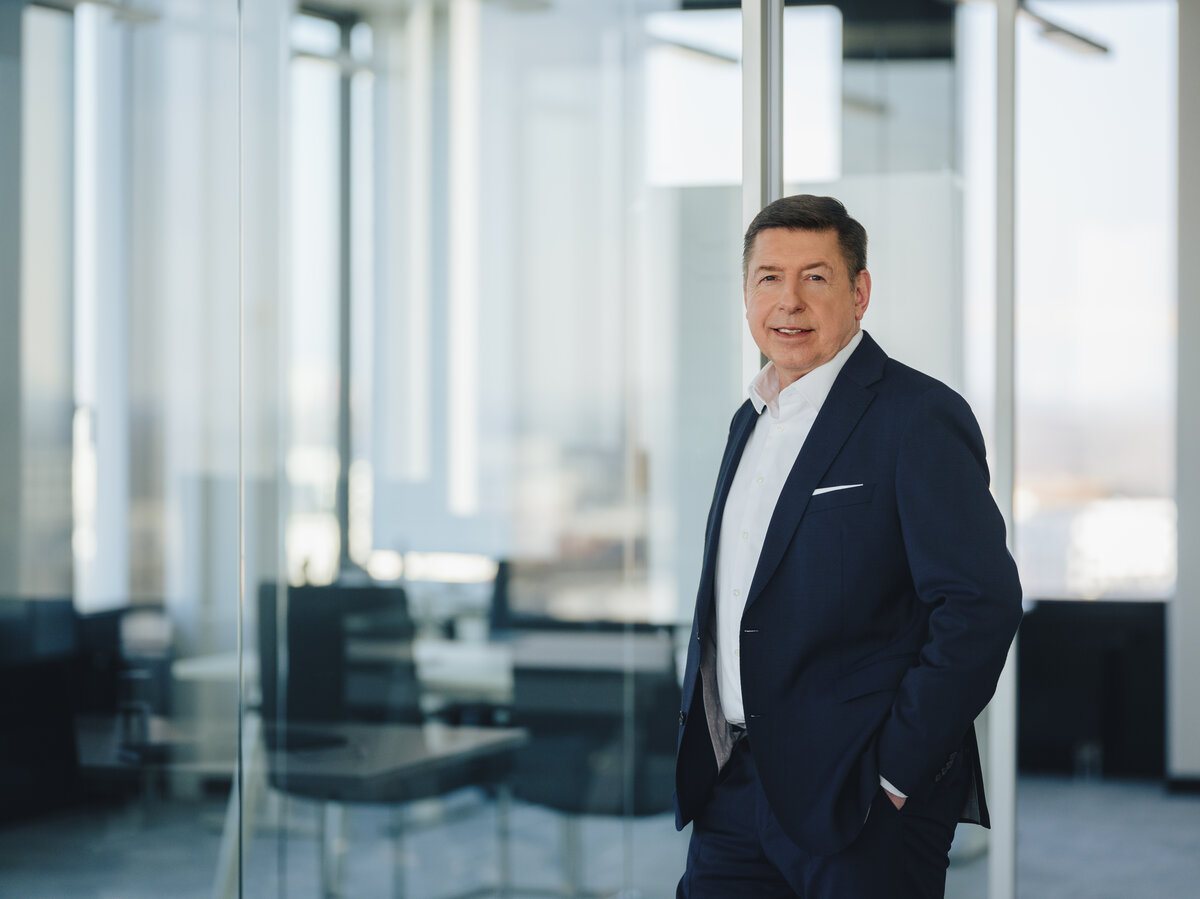 The image features Dr. Thomas Schulz, Bilfinger Group CEO, in a suit within a sleek office environment.