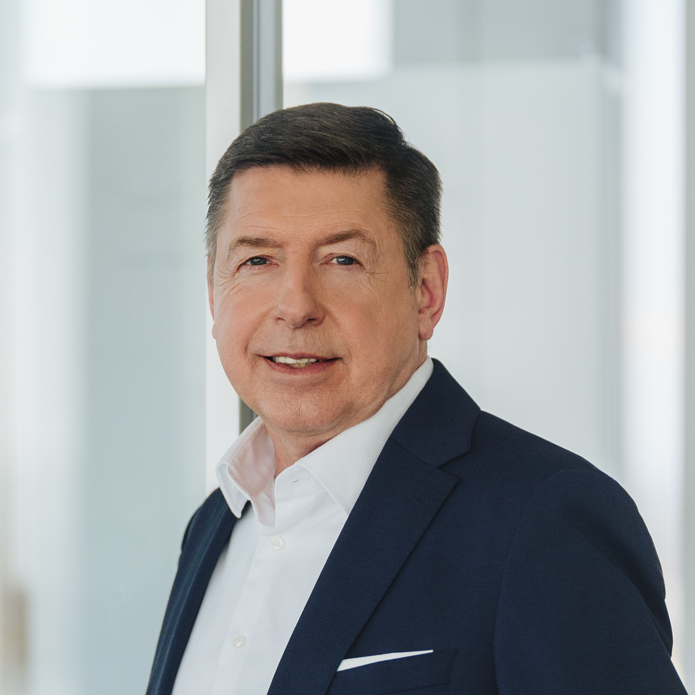The image features Dr. Thomas Schulz, Bilfinger Group CEO, in a suit within a sleek office environment.